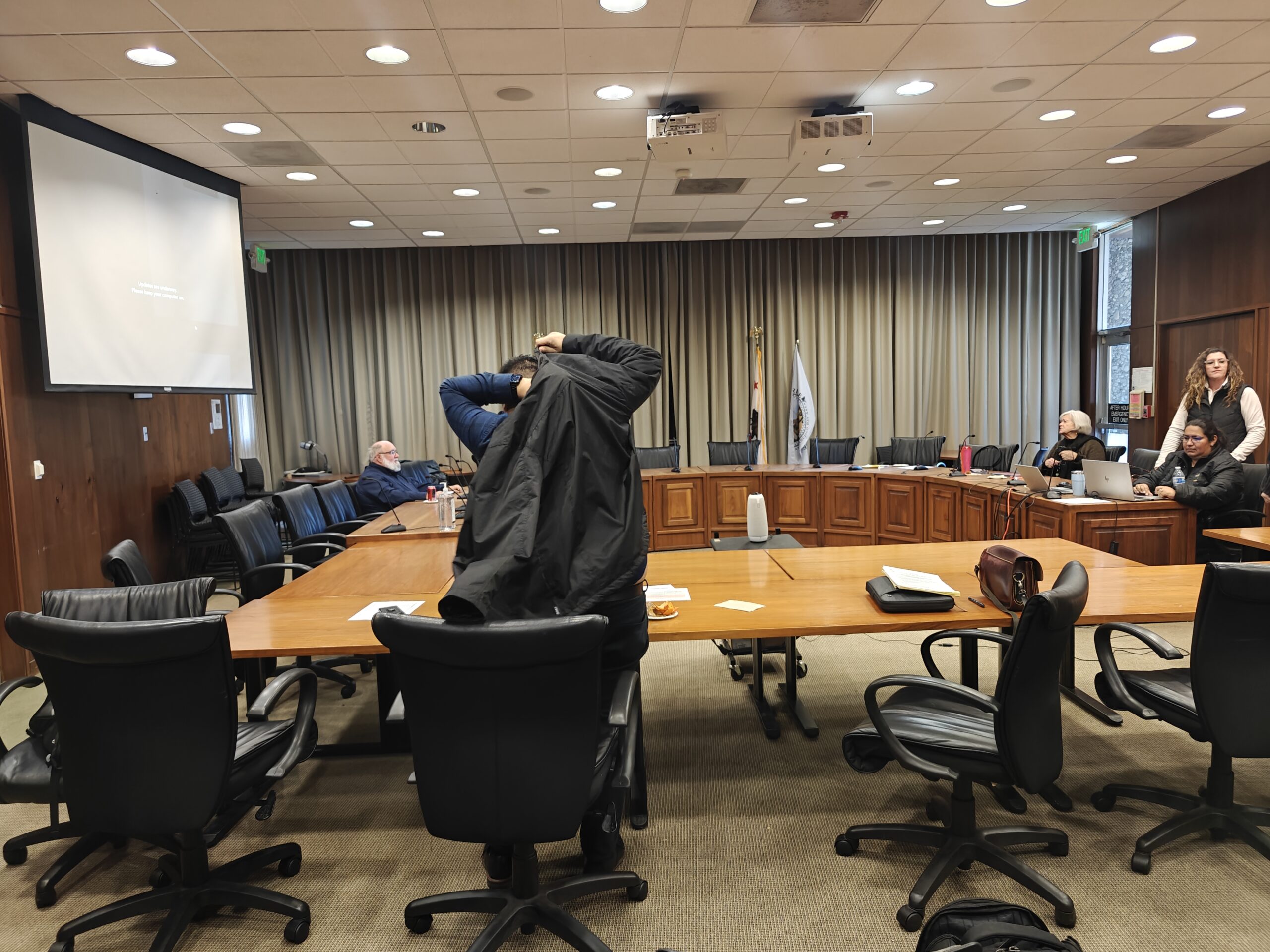 People in a meeting sitting around a formation of desks